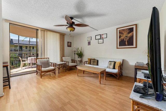 75-6026 Alii Dr Unit 5206, Kailua-Kona, HI 96740 - sitting room with ceiling fan, expansive windows, light wood-type flooring, and a textured ceiling