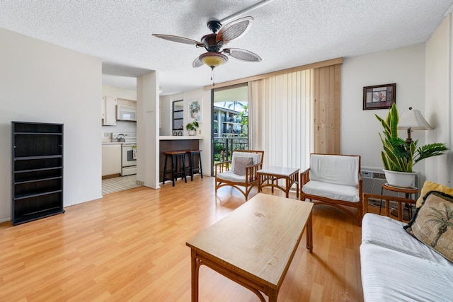 75-6026 Alii Dr Unit 5206, Kailua-Kona, HI 96740 - living area with a ceiling fan, light wood-type flooring, and a textured ceiling