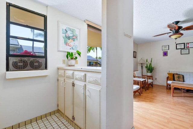 75-6026 Alii Dr Unit 5206, Kailua-Kona, HI 96740 - bar area with healthy amount of natural light, a textured ceiling, ceiling fan, and light wood-type flooring
