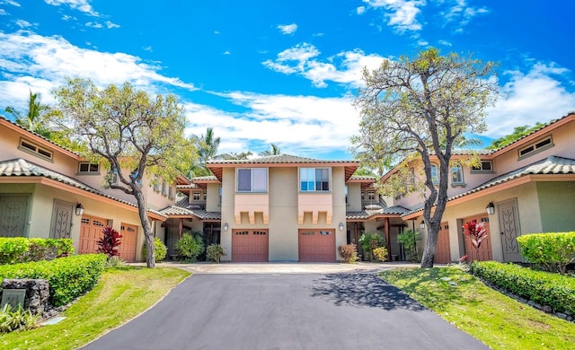 68-1125 Kaniku Dr Unit 2105, Kamuela, HI 96743 - mediterranean / spanish-style home with driveway, an attached garage, stucco siding, and a tiled roof