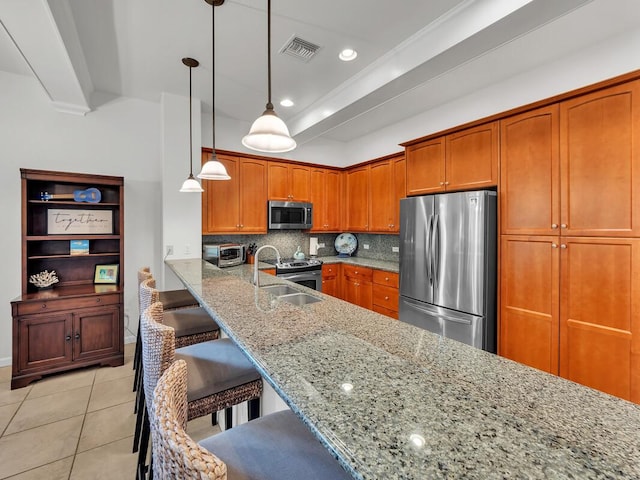 68-1125 Kaniku Dr Unit 2105, Kamuela, HI 96743 - kitchen featuring stainless steel appliances, brown cabinetry, light stone counters, tasteful backsplash, and a breakfast bar