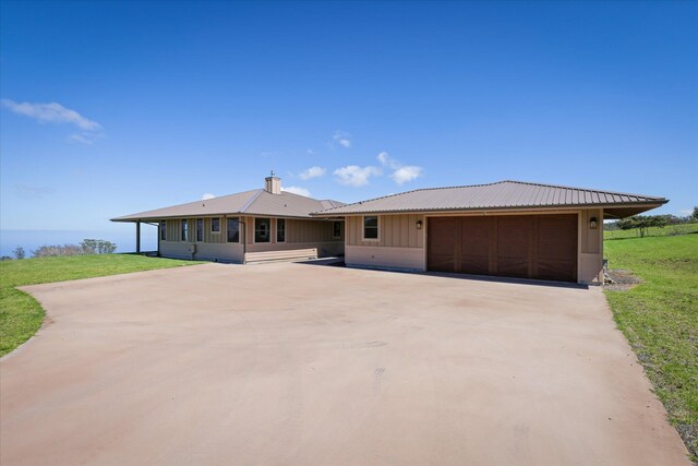 67-1027 Wainoenoe Rd, Kamuela, HI 96743 - view of front of house featuring a garage, board and batten siding, concrete driveway, a front yard, and metal roof