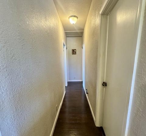15-2690 Mahimahi St, Pahoa, HI 96778 - hall featuring a textured wall, wood finished floors, and baseboards