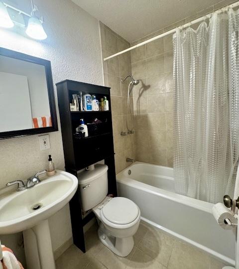 15-2690 Mahimahi St, Pahoa, HI 96778 - full bathroom featuring toilet, shower / bathtub combination with curtain, tile patterned flooring, and a textured wall
