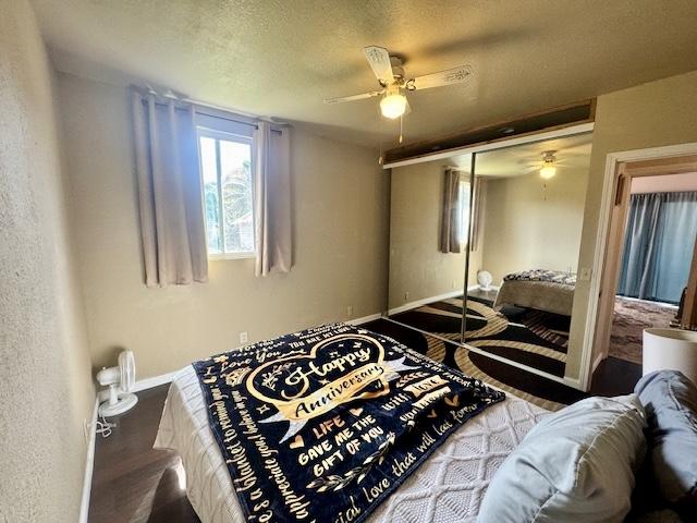 15-2690 Mahimahi St, Pahoa, HI 96778 - bedroom featuring baseboards, a textured ceiling, ceiling fan, a closet, and wood finished floors