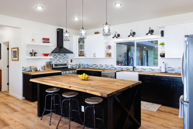 36-574 Spencer Rd, Laupahoehoe, HI 96764 - kitchen with butcher block countertops, open shelves, stainless steel appliances, wall chimney range hood, and recessed lighting