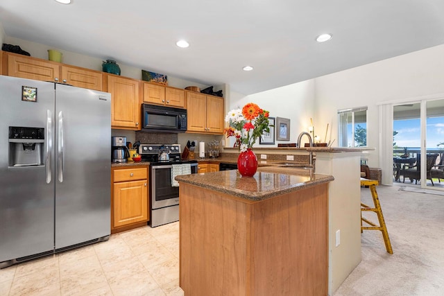 75-5919 Alii Dr Unit U23, Kailua-Kona, HI 96740 - kitchen featuring stainless steel appliances, a sink, a kitchen breakfast bar, recessed lighting, and dark stone countertops