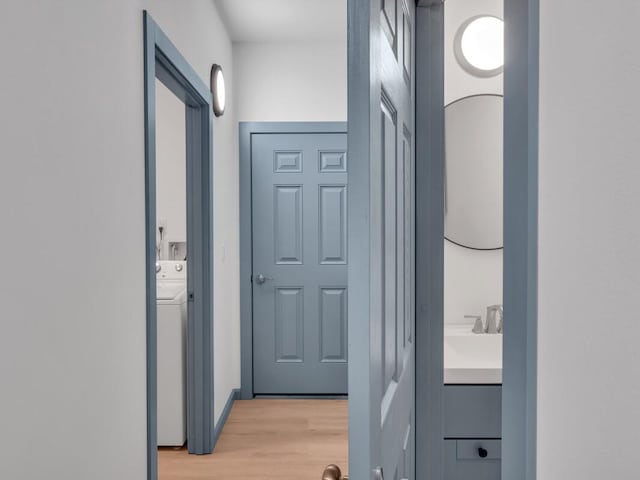 94-1679 Kaulua St, Naalehu, HI 96772 - hallway featuring light wood-style flooring, washer / dryer, and a sink