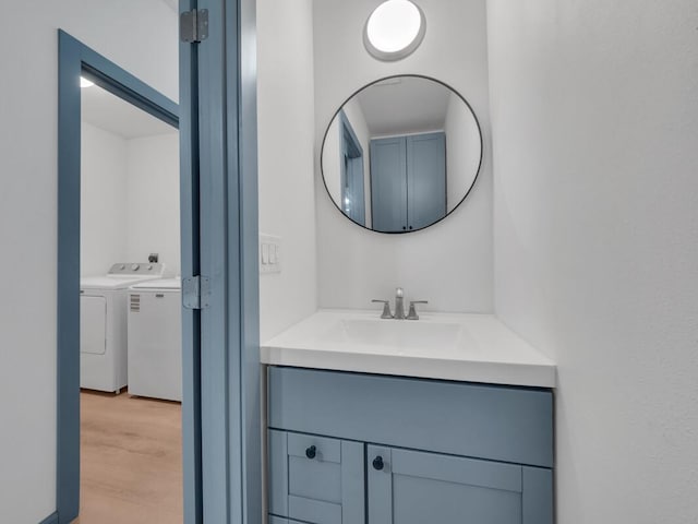 94-1679 Kaulua St, Naalehu, HI 96772 - bathroom featuring vanity, wood finished floors, and independent washer and dryer