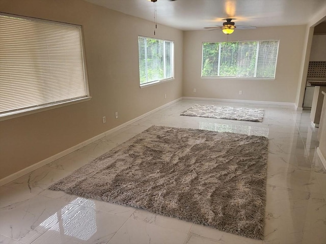 18-7862 N Lauko Rd, Mountain View, HI 96771 - unfurnished living room with light marble finish flooring, ceiling fan, and baseboards