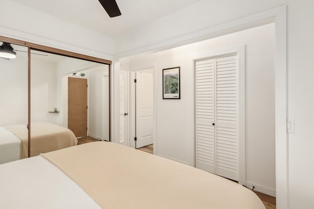 73-1099 Oluolu St, Kailua-Kona, HI 96740 - bedroom with multiple closets, light wood-style flooring, baseboards, and a ceiling fan