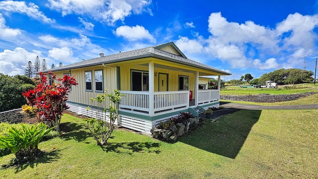 94-6663 Kamaoa Rd, Naalehu, HI 96772 - view of front of home with covered porch, a front yard, and board and batten siding