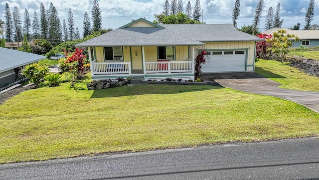 94-6663 Kamaoa Rd, Naalehu, HI 96772 - view of front facade featuring covered porch, asphalt driveway, an attached garage, roof with shingles, and a front yard