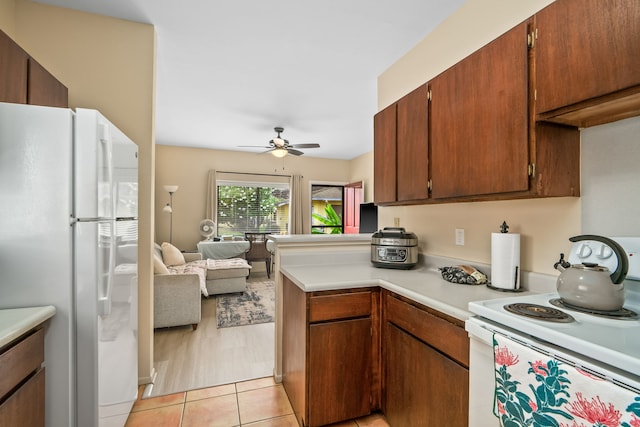4720 Menehune Rd, Waimea, HI 96796 - kitchen featuring white appliances, ceiling fan, light countertops, open floor plan, and a peninsula