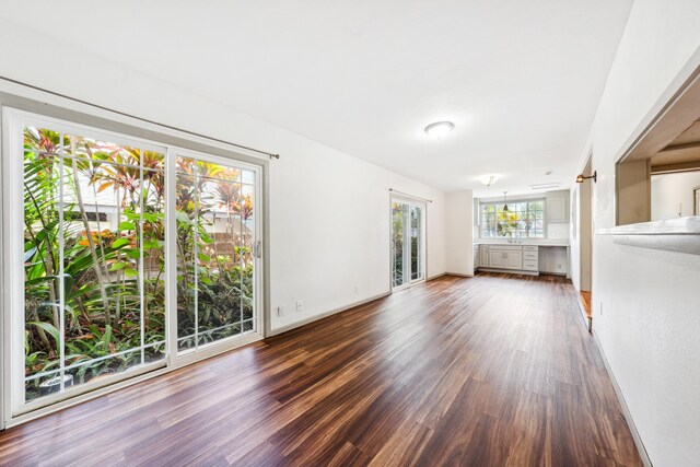 2969 Aloalo Pl, Lihue, HI 96766 - unfurnished living room featuring dark wood finished floors, baseboards, and a sink