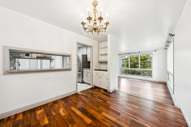 2969 Aloalo Pl, Lihue, HI 96766 - unfurnished living room with a chandelier, dark wood-style flooring, a sink, and baseboards