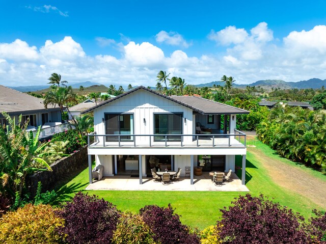 1647 Kelaukia St, Koloa, HI 96756 - rear view of house with a patio area, a mountain view, and a lawn