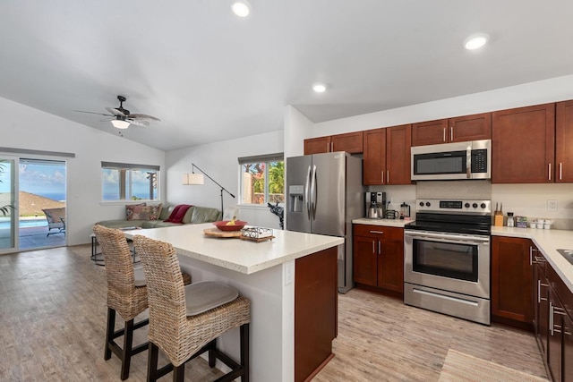 73-3725 Kaimalolo Pl, Kailua-Kona, HI 96740 - kitchen featuring stainless steel appliances, a breakfast bar area, light wood-type flooring, vaulted ceiling, and light countertops