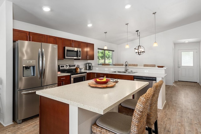 73-3725 Kaimalolo Pl, Kailua-Kona, HI 96740 - kitchen with stainless steel appliances, a sink, a peninsula, light wood-type flooring, and a kitchen breakfast bar