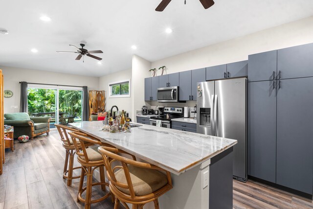 75-5726 Lamaokeola St, Kailua-Kona, HI 96740 - kitchen with stainless steel appliances, a sink, a ceiling fan, wood finished floors, and a kitchen breakfast bar