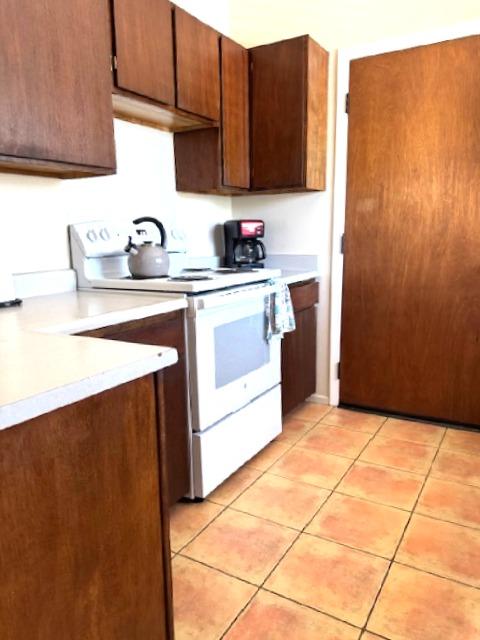 4724 Menehune Rd, Waimea, HI 96796 - kitchen featuring electric range, light countertops, and light tile patterned floors