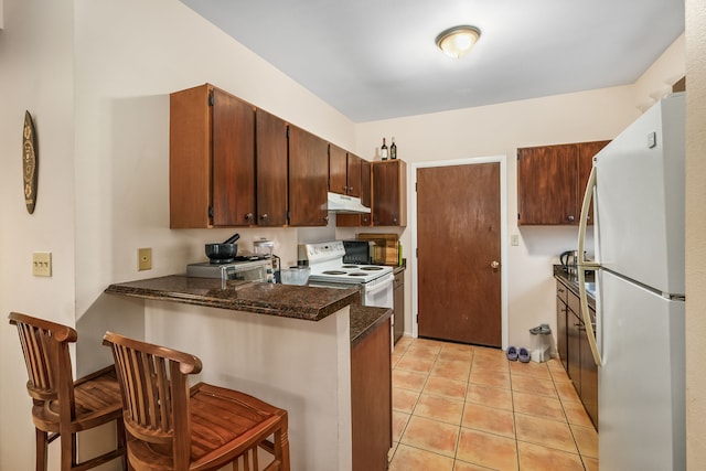 4724 Menehune Rd, Waimea, HI 96796 - kitchen featuring white appliances, under cabinet range hood, a peninsula, a breakfast bar, and light tile patterned floors
