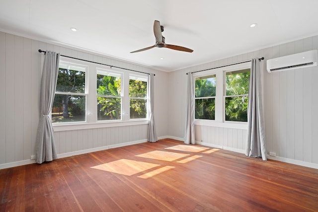 3018 Poipu Rd, Koloa, HI 96756 - unfurnished room featuring a wall unit AC, hardwood / wood-style flooring, a ceiling fan, and baseboards
