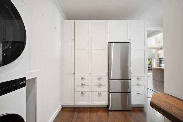 3018 Poipu Rd, Koloa, HI 96756 - kitchen featuring freestanding refrigerator, stacked washer / dryer, dark wood-style floors, and white cabinetry