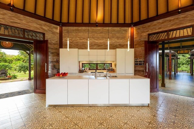 7218-C Koolau Rd, Kilauea, HI 96754 - kitchen featuring a towering ceiling, plenty of natural light, a sink, white cabinets, and light countertops