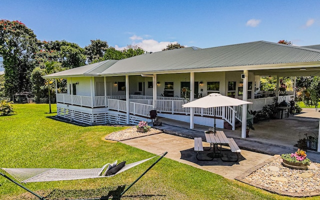28-387 Kulaimano Rd, Pepeekeo, HI 96783 - rear view of house with a yard, metal roof, a patio area, and covered porch