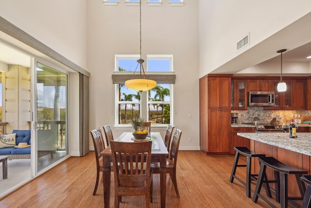2611 Kiahuna Plantation Dr Unit 2I, Koloa, HI 96756 - dining space with light wood finished floors, a high ceiling, and baseboards