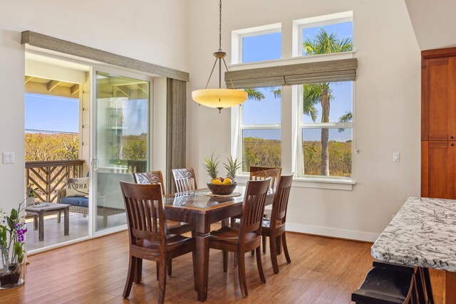 2611 Kiahuna Plantation Dr Unit 2I, Koloa, HI 96756 - dining room featuring plenty of natural light, light wood-type flooring, baseboards, and a towering ceiling