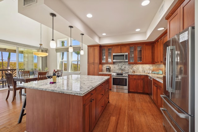 2611 Kiahuna Plantation Dr Unit 2I, Koloa, HI 96756 - kitchen featuring stainless steel appliances, plenty of natural light, wood finished floors, brown cabinets, and recessed lighting