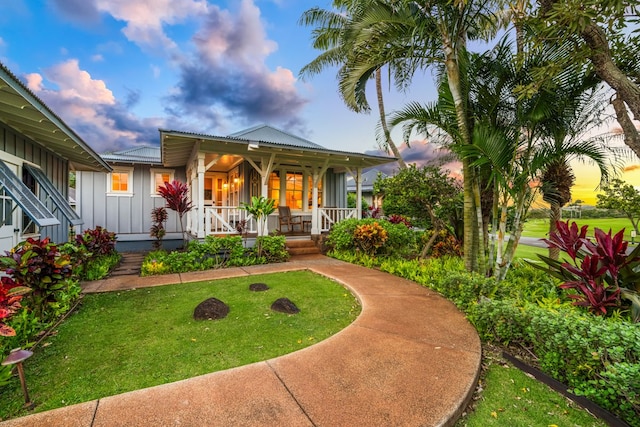 5145 Lau Nahele St, Koloa, HI 96756 - view of front of home featuring board and batten siding, covered porch, a front yard, and metal roof