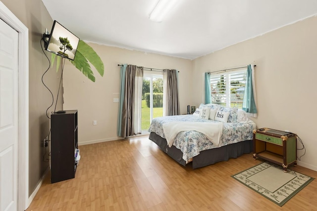 76 Makani Cir, Hilo, HI 96720 - bedroom with light wood-style flooring, access to outside, and baseboards