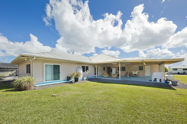 76 Makani Cir, Hilo, HI 96720 - back of house with stucco siding, a patio, a yard, and metal roof