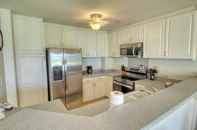 5250 Ka Haku Rd Unit 523, Princeville, HI 96722 - kitchen with appliances with stainless steel finishes, white cabinets, light countertops, and a sink
