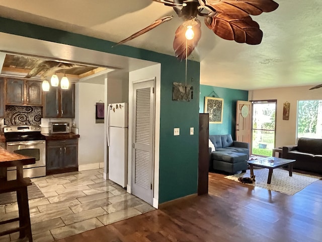 15-1784 30th Ave, Keaau, HI 96749 - kitchen featuring stainless steel electric range oven, freestanding refrigerator, a ceiling fan, and dark brown cabinets