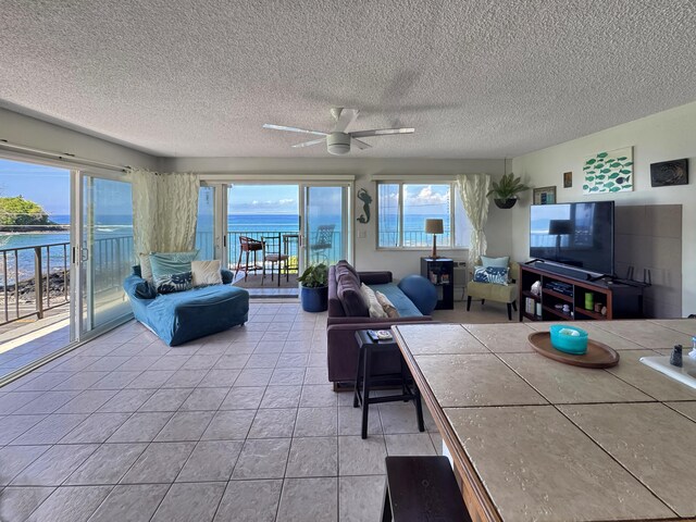 77-6311 Alii Dr Unit 306, Kailua-Kona, HI 96740 - living room featuring a ceiling fan, light tile patterned floors, and a textured ceiling