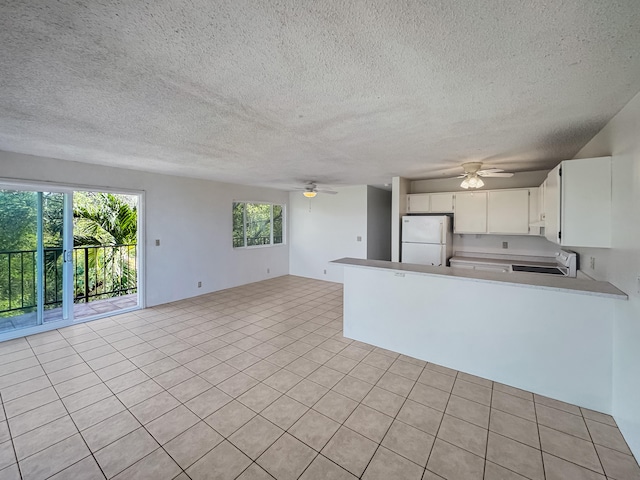 77-6311 Alii Dr Unit 301, Kailua-Kona, HI 96740 - kitchen featuring freestanding refrigerator, ceiling fan, open floor plan, white cabinetry, and light countertops