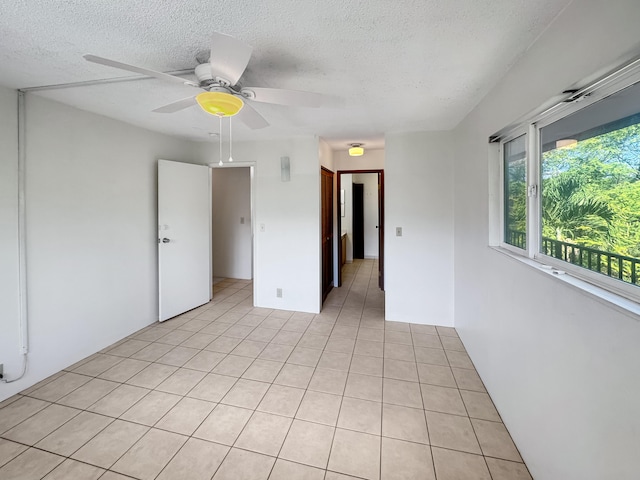 77-6311 Alii Dr Unit 301, Kailua-Kona, HI 96740 - empty room featuring a textured ceiling, light tile patterned floors, and a ceiling fan