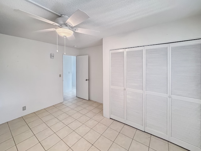77-6311 Alii Dr Unit 301, Kailua-Kona, HI 96740 - unfurnished bedroom featuring a closet, a textured ceiling, a ceiling fan, and light tile patterned flooring