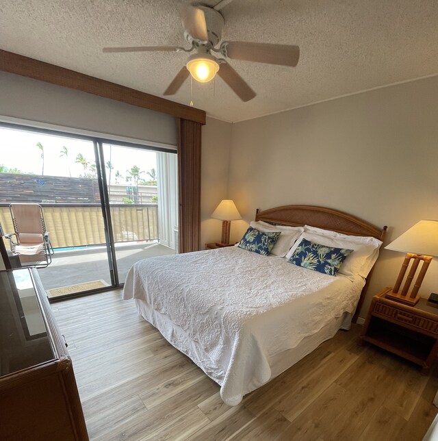 75-5719 Alii Dr Unit 409, Kailua-Kona, HI 96740 - bedroom with access to outside, a textured ceiling, wood finished floors, and a ceiling fan