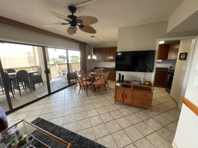 75-5719 Alii Dr Unit 409, Kailua-Kona, HI 96740 - living area featuring ceiling fan, light tile patterned floors, and a textured ceiling