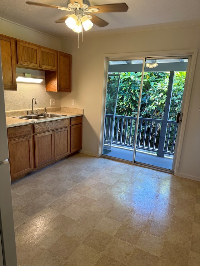 322 Ohai St Unit 16, Hilo, HI 96720 - kitchen with a sink, brown cabinetry, baseboards, and ceiling fan