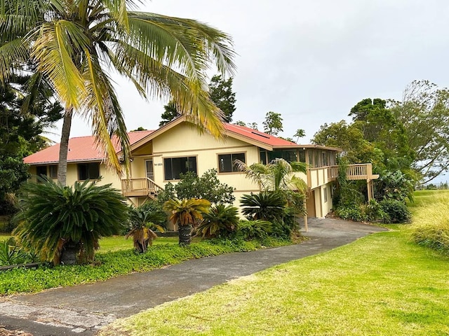 94-5826 Aouli Pl, Naalehu, HI 96772 - view of front facade with a front yard, driveway, and metal roof