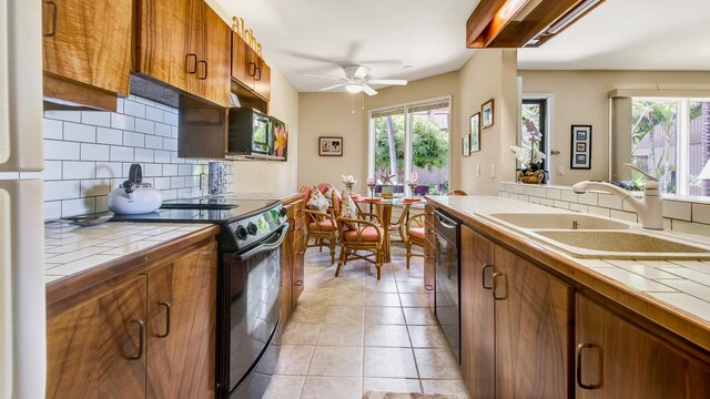 78-261 Manukai St Unit 3501, Kailua-Kona, HI 96740 - kitchen featuring tile counters, black appliances, brown cabinetry, and a ceiling fan