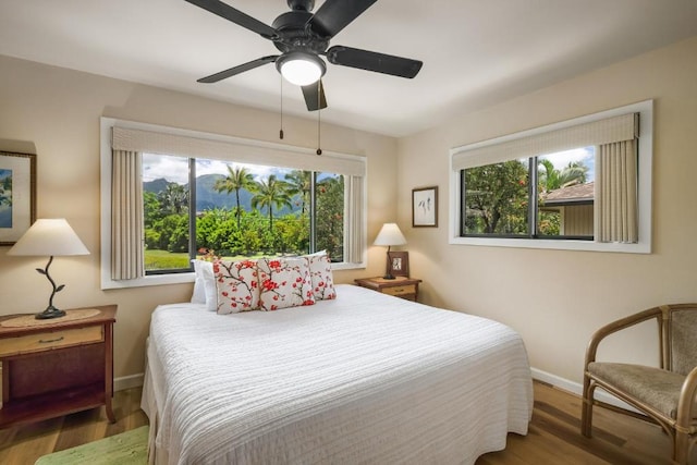 4800 Hanalei Plantation Rd Unit 9B, Princeville, HI 96722 - bedroom featuring multiple windows, baseboards, wood finished floors, and a ceiling fan