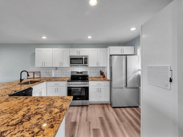 77-6585 Seaview Cir Unit 206, Kailua-Kona, HI 96740 - kitchen with appliances with stainless steel finishes, a sink, white cabinetry, light stone counters, and light wood finished floors