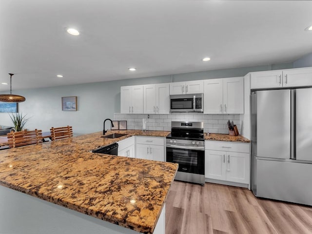 77-6585 Seaview Cir Unit 206, Kailua-Kona, HI 96740 - kitchen featuring appliances with stainless steel finishes, a sink, a peninsula, white cabinetry, and light stone counters